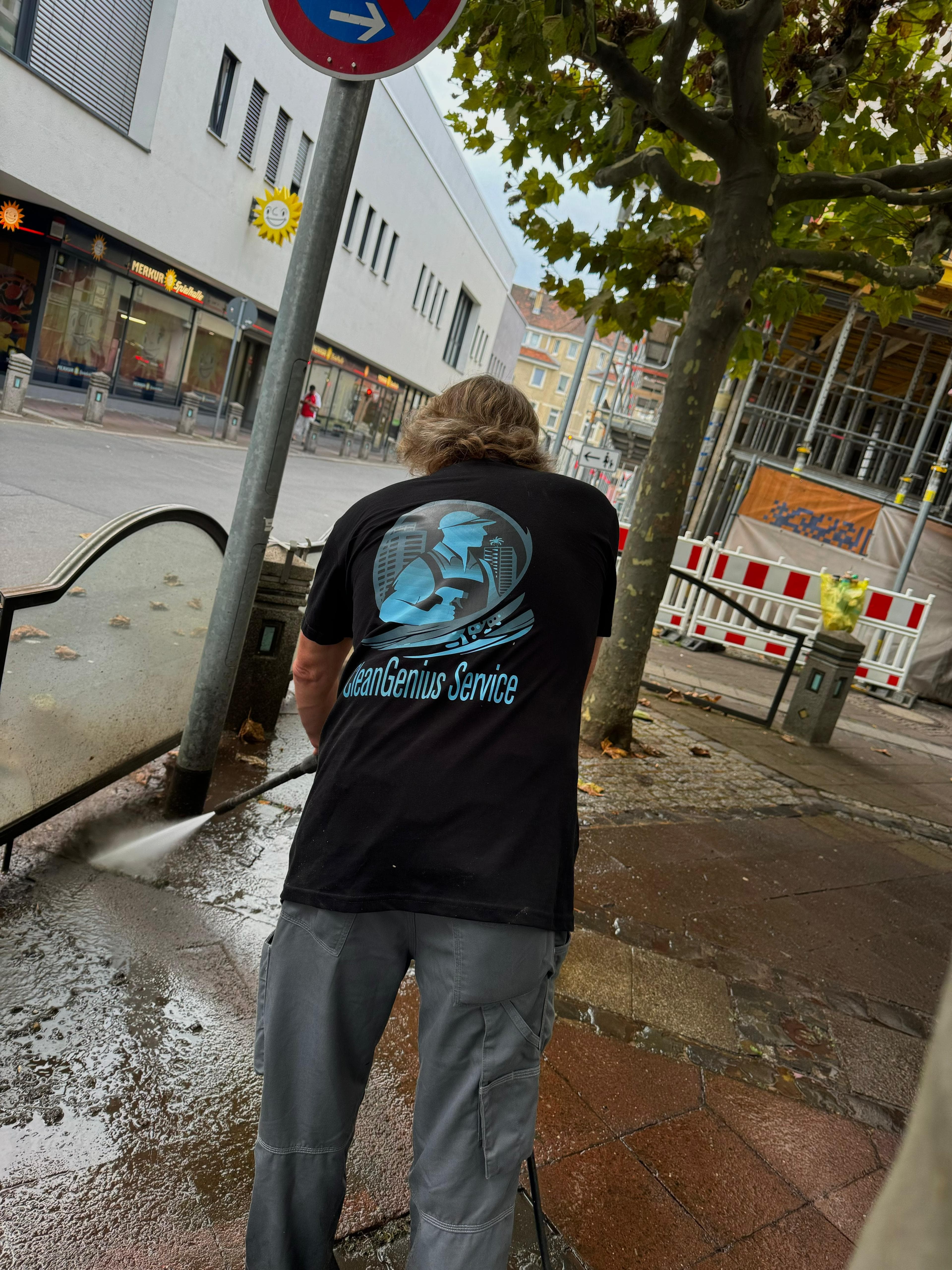 CleanGenius Mitarbeiter beim Hochdruckreinigen in Darmstadt – Logo auf dem Rücken