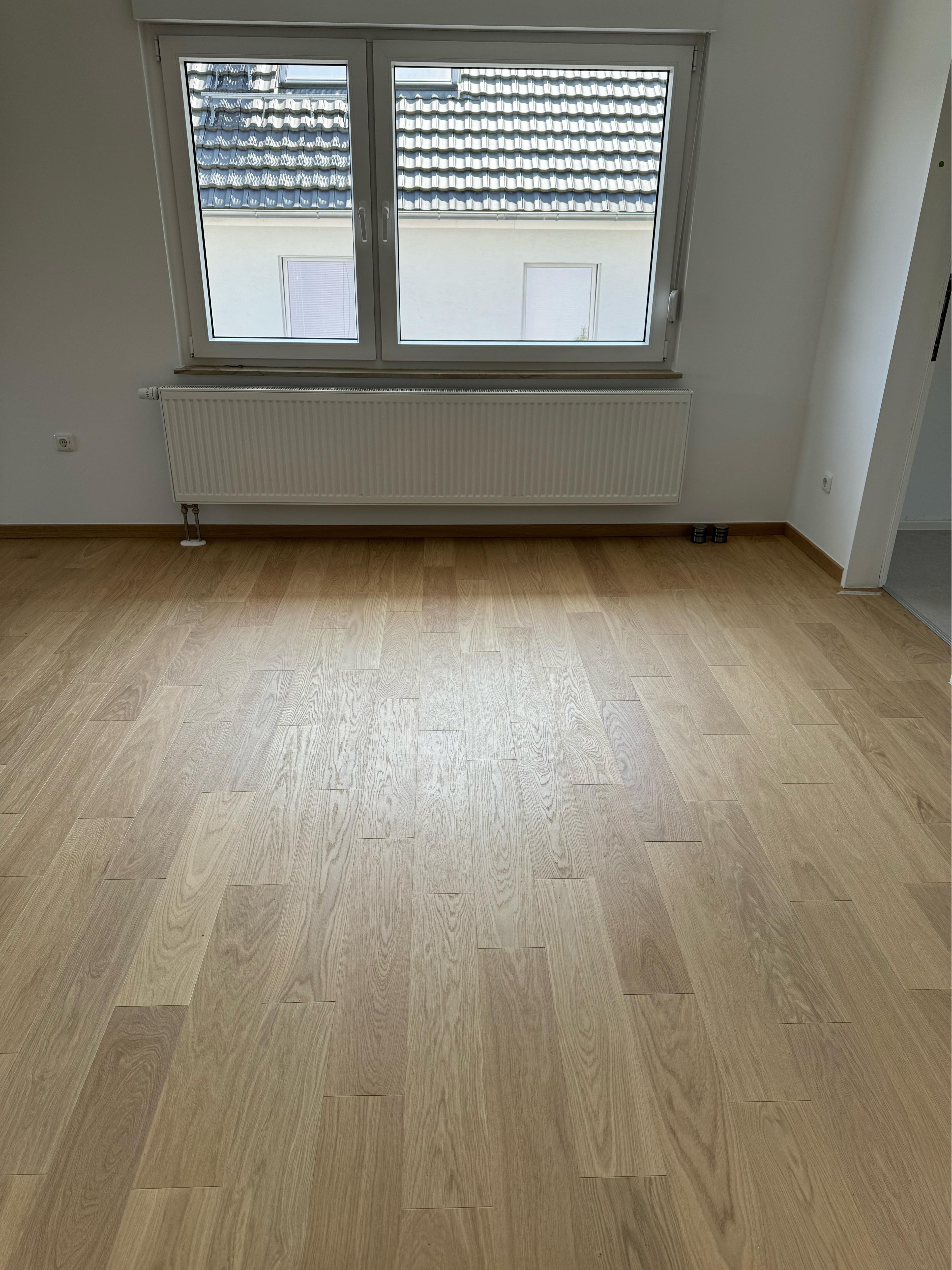 Gepflegter Raum mit Laminatboden und Heizkörper
